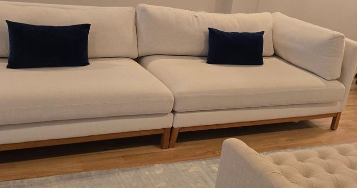 Pale sectional sofa, rug and hardwood floor in a Chicago apartment after a clean